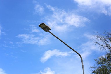 Gün boyunca sokak lambası direği ve iş konseptinizde tasarım için mavi gökyüzü arkaplanı.