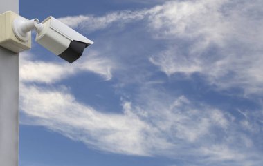 Mavi gökyüzü arkaplanı üzerindeki CCTV aracı, güvenlik sistemleri için ekipman ve tasarım için kopyalama alanına sahip.