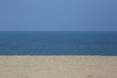 Bol kumlu bir sahil, mavi gökyüzü ve deniz manzaralı, gündüz vakti güzel deniz manzaralı..