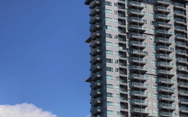 Gündüz vakti mavi gökyüzü arkaplanı olan yüksek binanın yanı ve iş konseptinizde tasarım için boşluk kopyala.