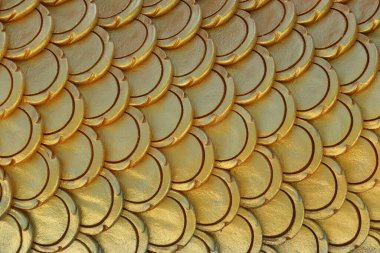 Balık pulu şeklinde altın desenli sıva, dizayn için istiflenmiş altın taneciklerin arka planı.