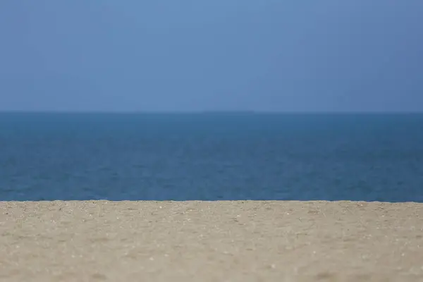 Stock image A beach with lots of sand and a backdrop of blue sky and sea,Beautiful seaside view in day time.