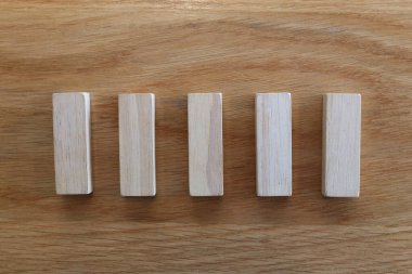 Sıraya dizilmiş beş ahşap yapboz, bir iş ya da oyuncak fikri.