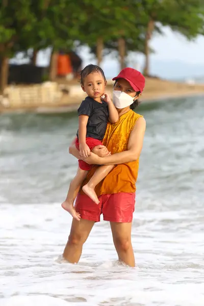 stock image Mother holding her child and playing on beach, Mother and child having fun to playing, Tropical sea beach of Thailand on a family vacation.