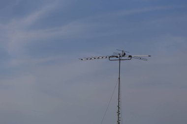 Antik televizyon anteni mavi gökyüzü arka planına kurulmuş..