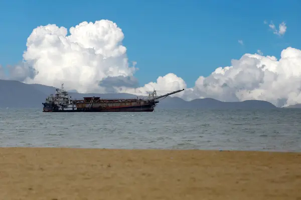 stock image A sand suction boat is working in the middle of the sea, in the background is a sky with white clouds.