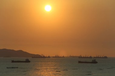 Deniz, alacakaranlıkta kargo gemileri ve balıkçı tekneleriyle doludur. Güneş batarken güneşin su yüzeyine yansıması doğadan gelen güzel bir ışıktır..