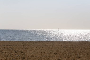 Deniz ve sahil, güneş ışığı köpüklü deniz suyuna yansıyan güzel görünüyor..