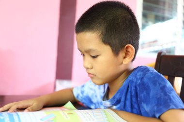 İçerde kitap okumaya derinden odaklanan küçük bir çocuk, öğrenmenin sevincini ve eğitimin önemini canlı bir ortamda göstermeye çalışıyor..