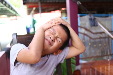 Genç bir çocuk rahat bir şekilde otururken bir takım duygular sergiliyor, samimi bir ortamda kişisel mücadele ve masumiyetini gösteriyor..