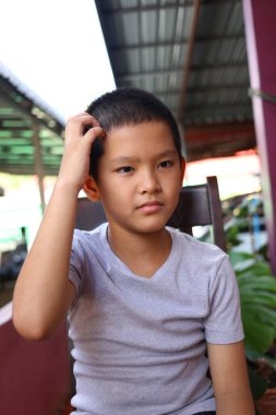 Gri tişörtlü düşünceli genç bir çocuk gündelik bir ortamda oturuyor. Kafasını kaşıyarak bir takım duygular sergiliyor. Masumiyet ve merakı somutlaştırıyor..