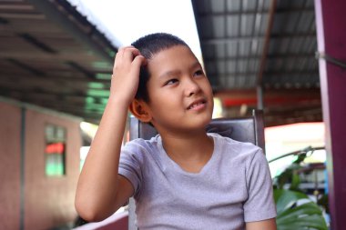 Düşünceli genç bir çocuk dışarıda gri bir gömlekle oturur, hayatı yansıtır. Onun ifadesi bir masumiyet ve merak duygusu taşır. Çocukluk anılarını yakalamak için mükemmel..