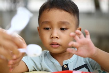 Odaklanmış genç bir çocuk oyuncu oyuncakları keşfediyor, merak ve neşe sergiliyor. Onun anlamlı jestleri kaygısız bir atmosferde çocukluğun masumiyetini vurgular..