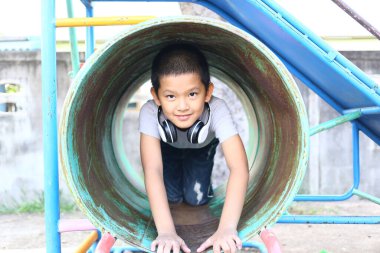 Neşeli bir çocuk renkli bir oyun parkında oynamaktan hoşlanır, metro kaydırağında sürünmekten. Bu resim çocukluk sevincinin ve keşiflerin özünü yakalar..