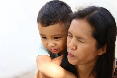 Bir anne ve çocuğu arasında geçen neşeli bir an. Neşeli bağlarını ve aile sevgisinin sıcaklığını açık havada sergiliyor..