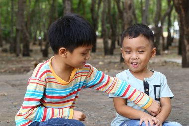 İki neşeli çocuk, açık hava maceraları sırasında gerçek dostluk ve masumiyetlerini sergiledikleri doğal ortamda neşeli bir anı paylaşıyorlar..
