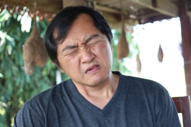 Doğa ile çevrili bir ortamda güçlü bir duygu ifade eden bir adam, günlük hayatta samimiyet ve düşünceli bir an sergiliyor..