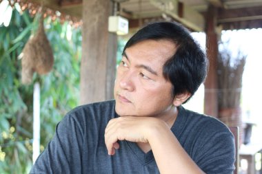 Düşünceli bir adam uzaklığa bakar, doğal ortamda hayatı yansıtır, sükuneti ve iç huzuru somutlaştırır ve sakin bir açık hava ortamında gözlemler..