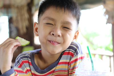 Neşeli bir çocuk ferahlatıcı bir içki ve limon dilimi ile saf neşe ve masumiyet sunuyor. Çocukluk temaları için mükemmel.
