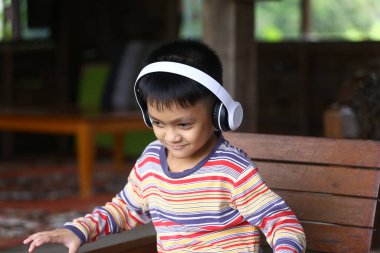 Neşeli bir çocuk, kapalı bir ortamda kulaklık takarak müzik dinlemekten, mutluluk ve rahatlama yaymaktan hoşlanır. Yaşam tarzı temaları için mükemmel.