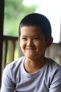 İçerideki neşeli genç bir çocuk kendinden emin bir gülümseme sergiliyor, çocukluk mutluluğunun ve masumiyetin özünü samimi bir anda yakalıyor..