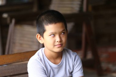 Neşeli bir çocuk eşsiz bir ifade sergiliyor, merakını ve masumiyetini gösteriyor. Bu samimi portre, rahat bir iç mekandaki gençlik neşesinin özünü yansıtıyor..