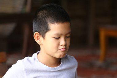 Ciddi bir ifadeye sahip düşünceli genç bir çocuk içeride oturur ve düşüncelerini yansıtır. Gündelik an, gençliği ve masumiyeti yakalar..