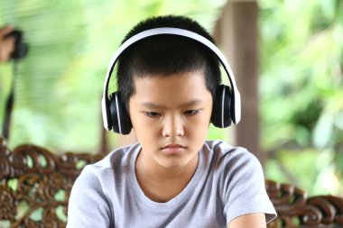 Kulaklık takan genç bir çocuk ciddi bir ifadeyle oturur, müziğe dalmıştır. Ayar sıradan, huzurlu bir konsantrasyon ve rahatlama anı yakalıyor..