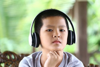 Genç bir çocuğun kulaklık taktığı ve müzik dinlediği görülüyor. Dışarıdaki dingin ortam, gençliğin masumiyetini yakalayan eğlence ve neşe havasını arttırır..