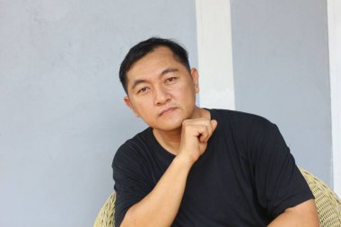 Düşünceli, sıradan giyinmiş bir adamın evde rahat bir şekilde oturduğu görülüyor. İfadesi derin düşüncelere dalmayı ve içgözlem yapmayı öneriyor. Huzurlu bir hava yaratıyor..