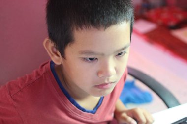 Düşünceli genç bir çocuk öğrenmekle meşgul. Odaklanma ve merak gösteriyor. Parlak çevre onun eğitim faaliyetlerine yoğunlaşmasını vurguluyor.