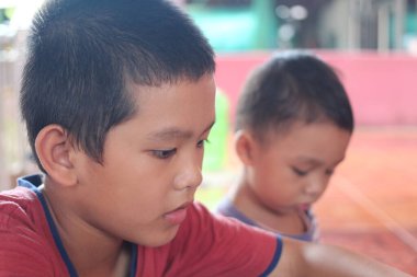İki çocuk ev içinde oyuncu bir keşfe dalmış, odak ve neşe gösteriyorlar. Bu samimi an çocukluk masumiyetinin ve yaratıcılığının özünü yakalıyor..