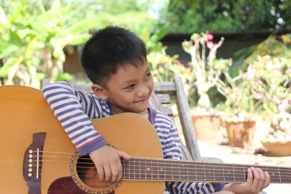 Neşeli bir çocuk doğayla çevrili akustik bir gitar çalar. Anlamlı gülüşü, açık hava ortamında gençliğin ve yaratıcılığın özünü yakalıyor..