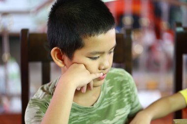 Düşünceli çocuk evde otururken sessizce yansıtır. Çocukların ciddi ifadesi bir anlık içgözlem, masumiyet ve konsantrasyon göstergesi..