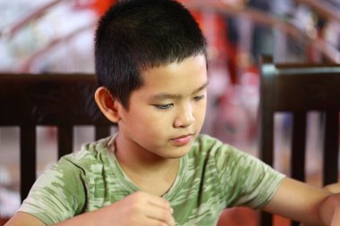 Genç bir çocuk evde yemek yerken yakalandı. Çocukluk masumiyetinin iç açıcı bir anında odak ve neşe gösteriyordu..