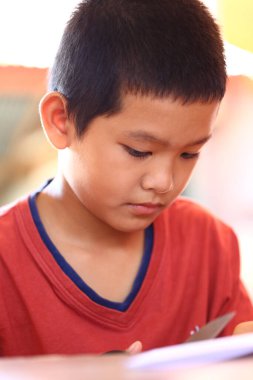 Konsantrasyonunu ve yaratıcılığını sergileyen, bir sanat aktivitesine odaklanmış bir çocuğun yakın çekimi. Sıcak renkler çocukluğun masumiyetini yansıtır..