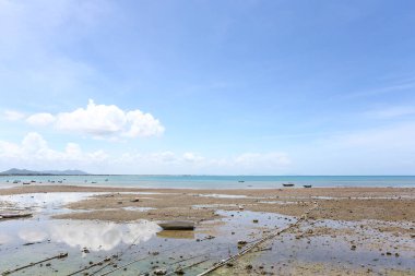 Samae San sahili kuruyken, gökyüzünde beyaz bulutlar ve Tayland 'ın Chonburi eyaletinde demirlemiş balıkçı tekneleri var..