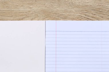 Tahta bir masanın üzerindeki boş defter yazmak ya da çizim yapmak için mükemmel bir yer sunuyor. İlham arayan öğrenciler, yazarlar ve yaratıcılar için idealdir..