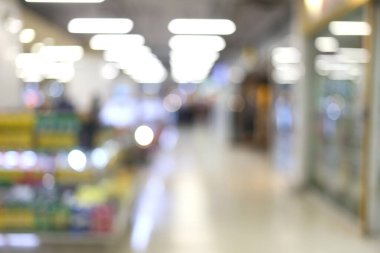 Bir alışveriş merkezinin yumuşak odaklı görüntüsü bulanık ışıklar ve kapalı mekan unsurları ile ilgi çekici bir ortam yaratıyor, çağdaş perakende temaları için mükemmel..