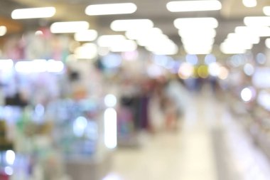 Bir alışveriş merkezinin yumuşak odaklı görüntüsü bulanık ışıklar ve kapalı mekan unsurları ile ilgi çekici bir ortam yaratıyor, çağdaş perakende temaları için mükemmel..