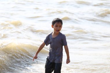 Neşeli bir çocuk sahildeki sığ sularda durur, sıcak bir yaz gününde sıçramaların ve kahkahaların heyecanını tecrübe eder, tasasız çocukluk sevincini somutlaştırır..