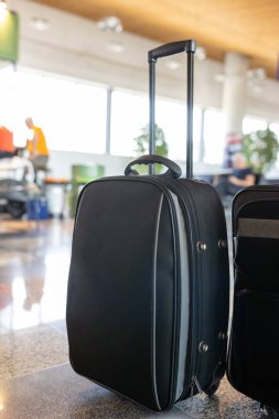 Bulanık bir arka planda havaalanında seyahat için tekerlekli bavullar.