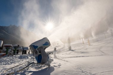 Slovenya 'nın Kranjska Gora kentinde soğuk güneşli bir kış gününde kar makineli kar topu veya top eylemi