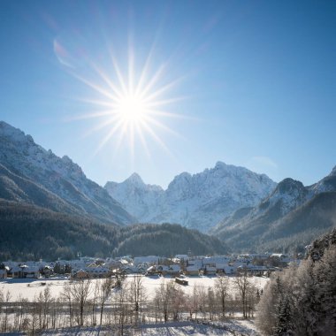 Slovenya 'dan Kranjska Gora kışın karla kaplanırken, arkada Julian Alps ve Triglav Ulusal Parkı yer alıyor