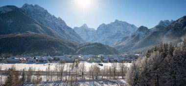 Slovenya 'dan Kranjska Gora kışın karla kaplanırken, arkada Julian Alps ve Triglav Ulusal Parkı yer alıyor