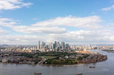 Londra, İngiltere - 11 Eylül 2022 - Canary Wharf bütünüyle doğudan ufuk çizgisi, yüksek konut ve iş binaları, ve yakınlardaki alçak katlı rıhtım adaları İHA atışı.