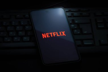 Ljubljana, Slovenia - 21 January 2023: Netflix logo on smartphone screen laying on computer keyboard