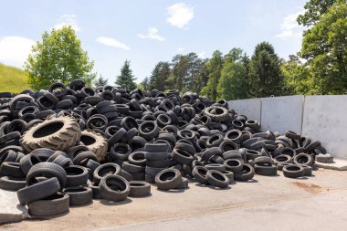 Heap of old used industrial rubber tires specially selected from the garbage in a recycling plant for separate recycling