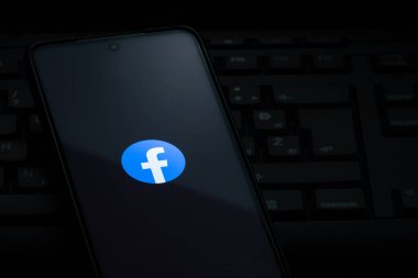 Ljubljana, Slovenia - 21 January 2023: Facebook logo on smartphone screen laying on computer keyboard