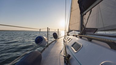 Yelkenli yat rengarenk günbatımında denizde yüzüyor.